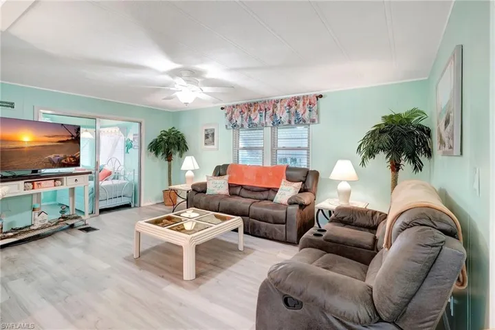 Living room with ceiling fan and light hardwood / wood-style floors