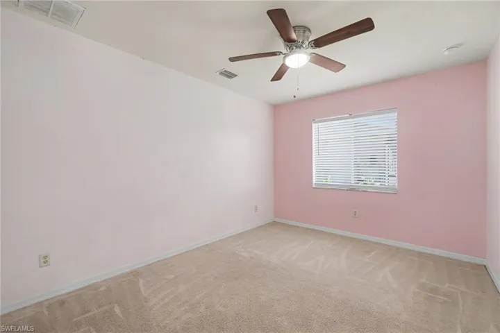 Room featuring light pink walls and neutral carpet flooring