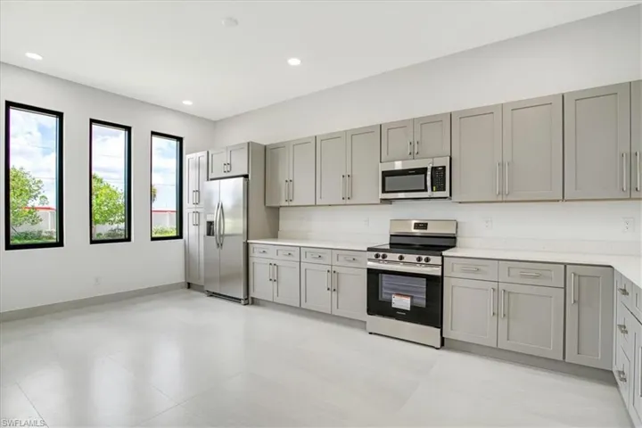 Kitchen with gray cabinetry and appliances with stainless steel finishes