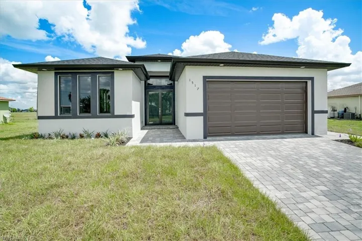 View of front of home featuring a garage and a front yard