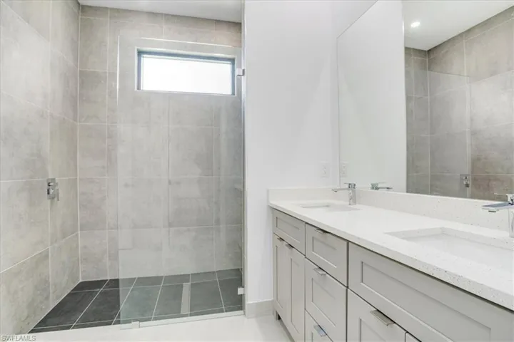 Master Bathroom with vanity and a tile shower