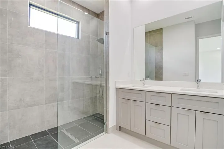 Master Bathroom featuring vanity, tiled shower, and tile patterned floors