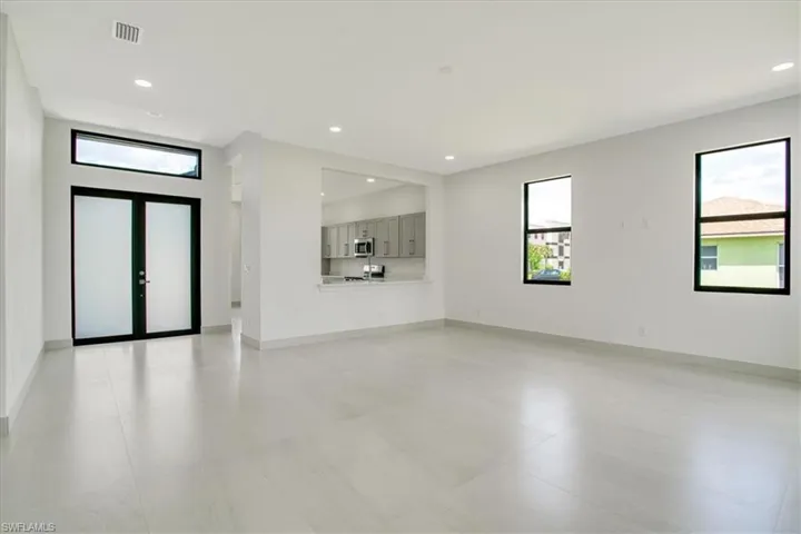Unfurnished living room with plenty of natural light and french doors