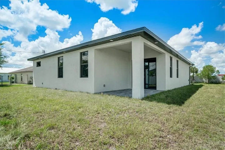 Rear view of property featuring a yard and a patio