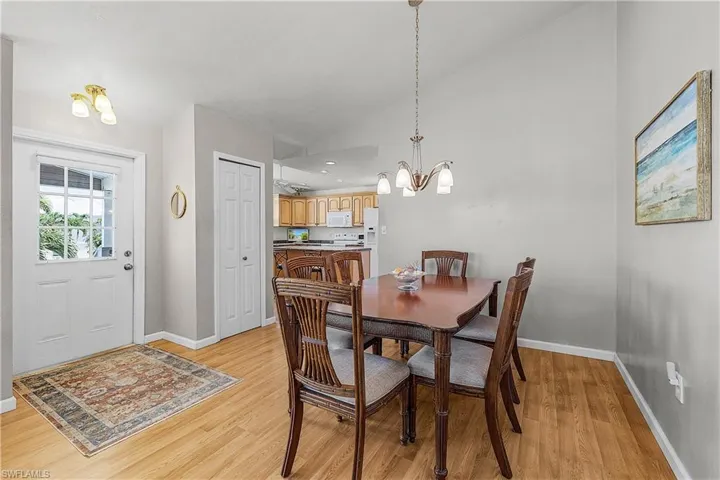 Dining room featuring a chandelier, vaulted ceiling, and light wood-type flooring
