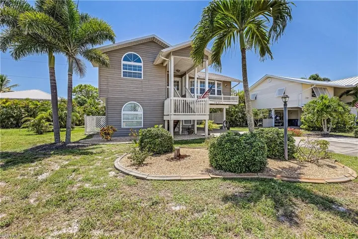 Raised beach house with a front yard and a balcony