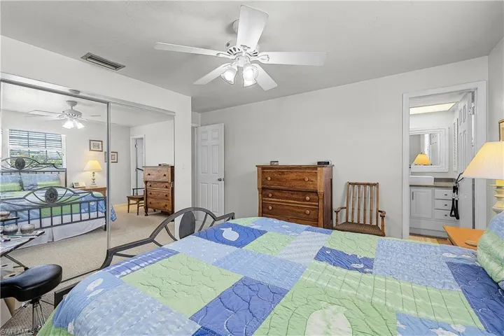 Bedroom with a closet, a ceiling fan, carpet floors, and connected bathroom