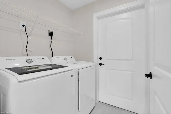 Laundry room featuring light tile patterned floors and separate washer and dryer