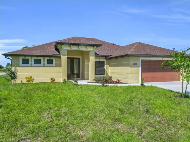 Prairie-style house featuring roof with shingles, a front yard, stucco siding, a garage, and concrete driveway