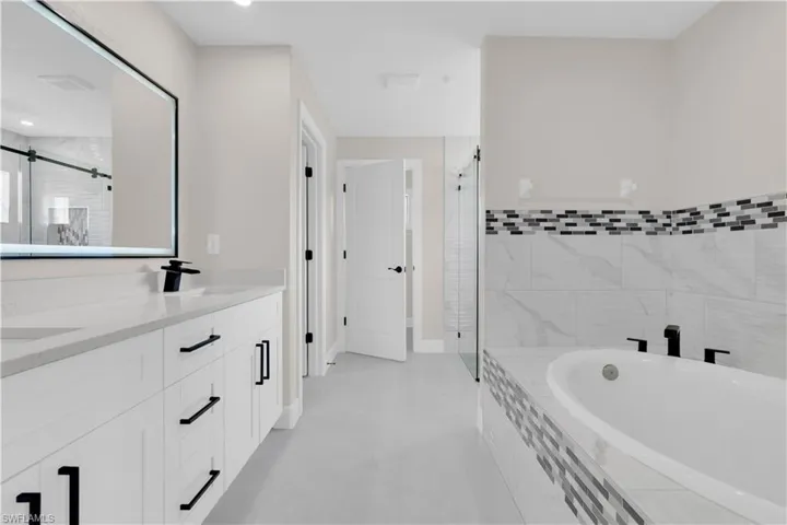 Bathroom with a shower stall, a garden tub, and double vanity