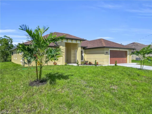 Prairie-style home featuring a front lawn, an attached garage, stucco siding, concrete driveway, and roof with shingles