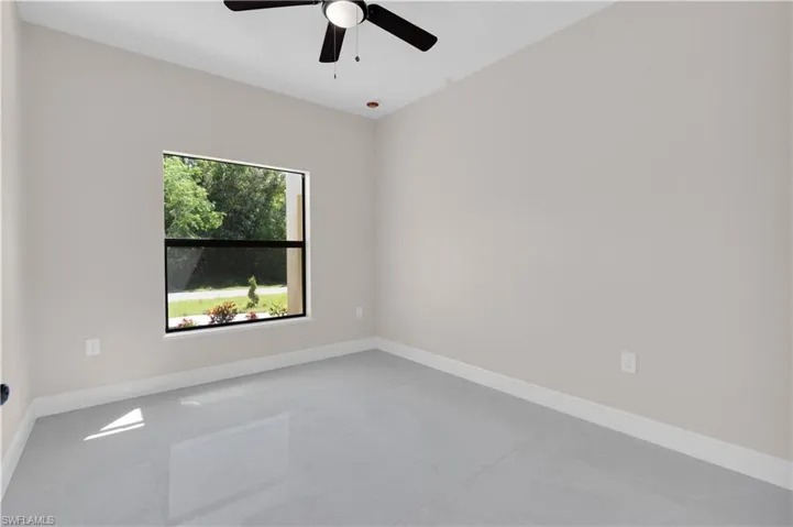 Unfurnished room with baseboards and a ceiling fan