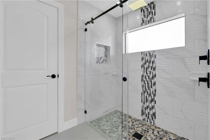 Full bath featuring a shower stall and tile patterned flooring