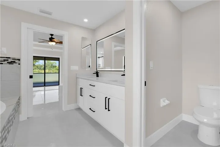 Bathroom with double vanity, light tile patterned floors, recessed lighting, and a ceiling fan