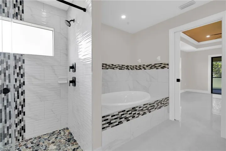 Full bathroom featuring a bath, a shower stall, and recessed lighting