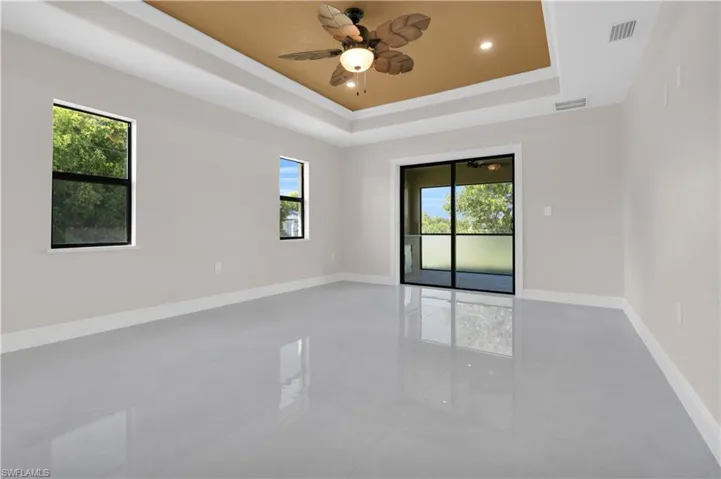 Unfurnished room with a tray ceiling, crown molding, ceiling fan, light tile patterned floors, and recessed lighting