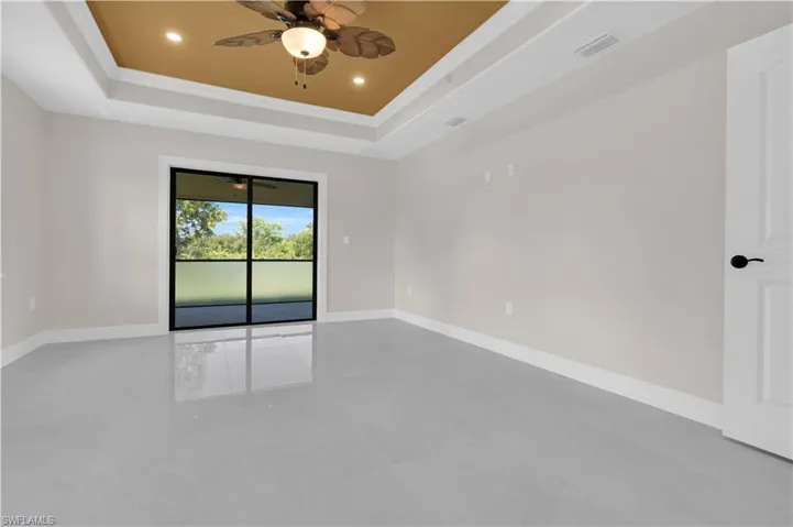 Spare room with a tray ceiling, a ceiling fan, recessed lighting, and ornamental molding