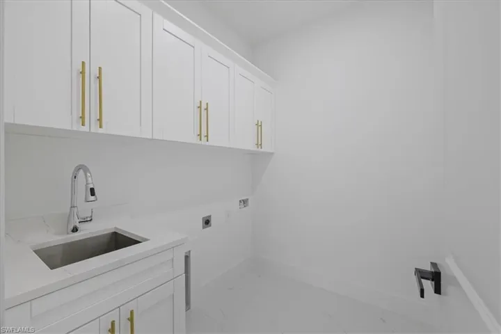 Laundry room featuring washer hookup, hookup for an electric dryer, and cabinet space