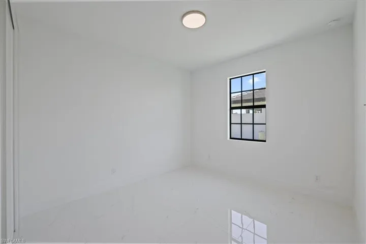 Empty room with baseboards and marble look tiles