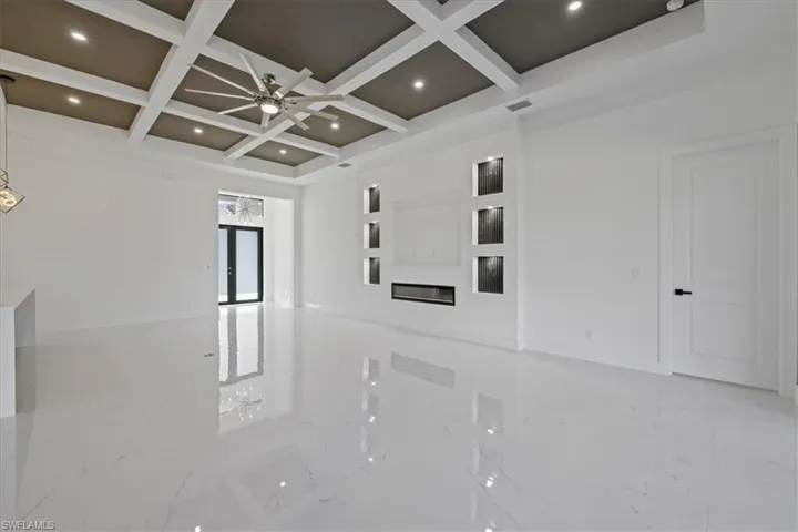 Spare room with a ceiling fan, coffered ceiling, and recessed lighting