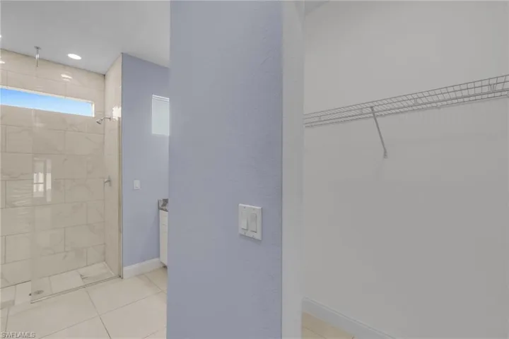 Bathroom with tile patterned flooring and a tile shower