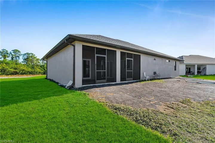 Back of house with a sunroom and a yard