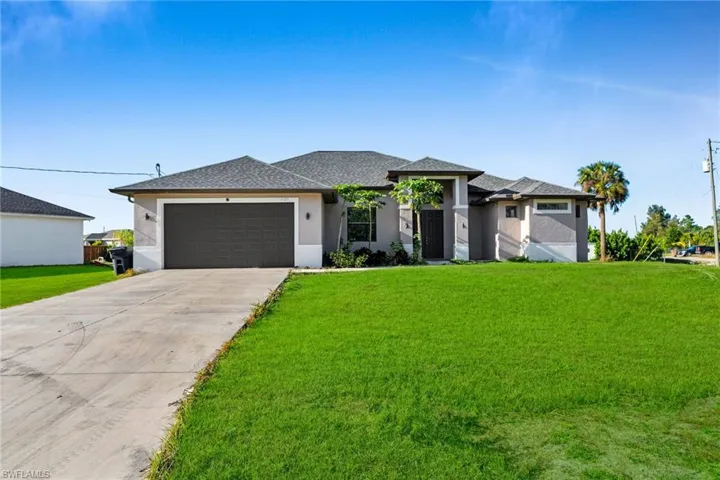 View of front of house with a front yard and a garage
