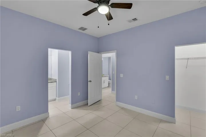Unfurnished bedroom with a closet, ceiling fan, and light tile patterned flooring