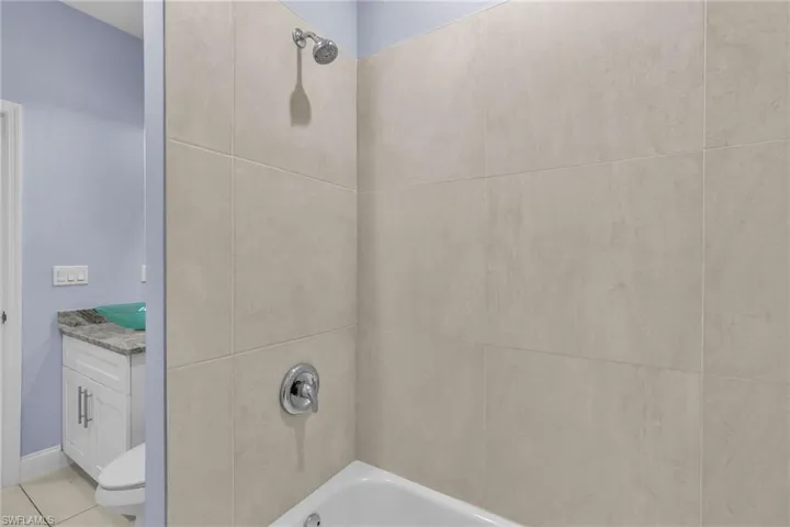 Full bathroom featuring tile patterned floors, vanity, toilet, and tiled shower / bath