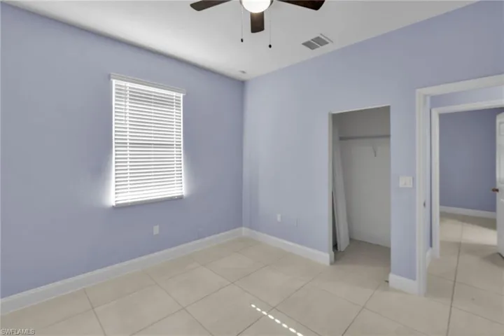 Unfurnished bedroom featuring ceiling fan, a closet, and light tile patterned flooring
