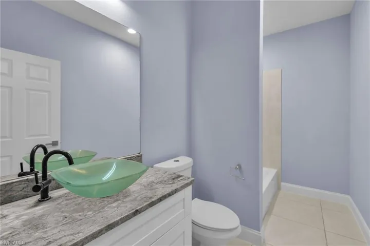 Bathroom with tile patterned flooring, vanity, and toilet