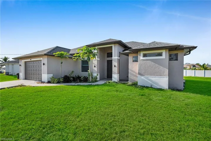 Prairie-style house featuring a front lawn and a garage