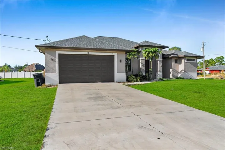 View of front of property with a front yard and a garage