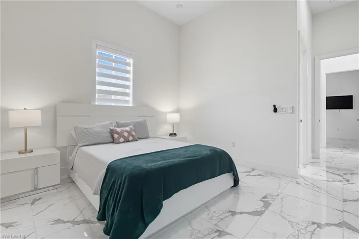 Bedroom with light marble finish floors and baseboards