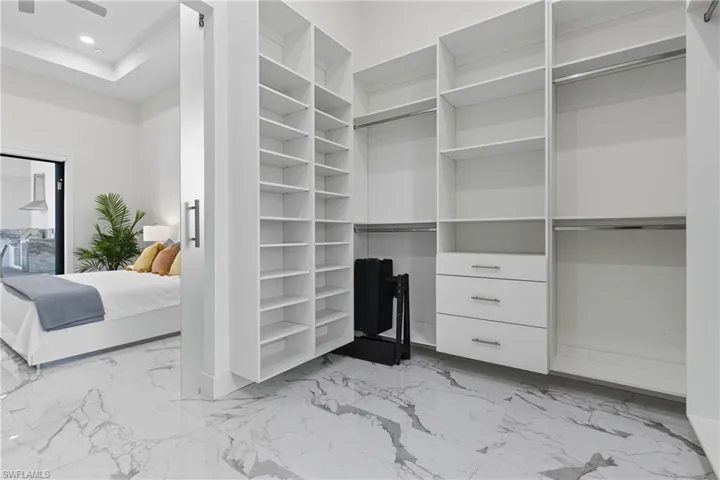Spacious closet with light marble finish floors
