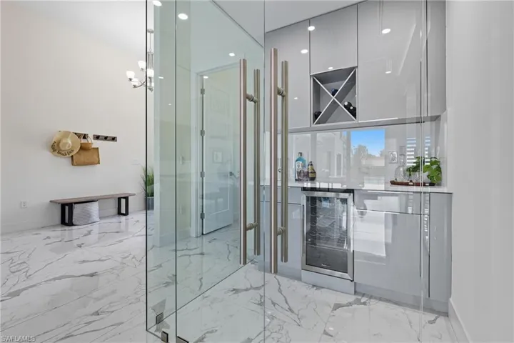 Corking Room with wine cooler, light marble finish floors, and recessed lighting