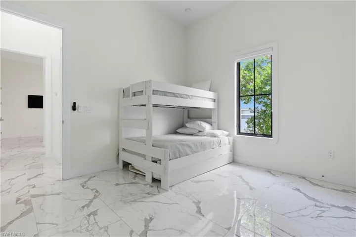 Bedroom with light marble finish floors and baseboards