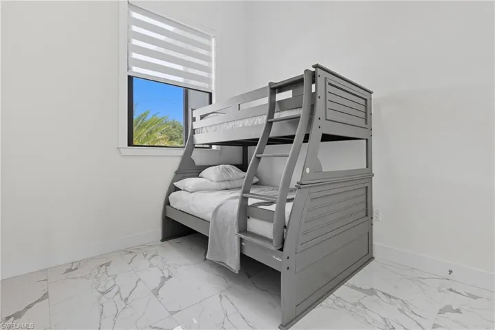 Bedroom with light marble finish flooring