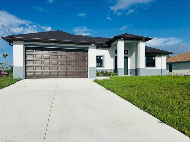 Prairie-style home with a garage and a front yard