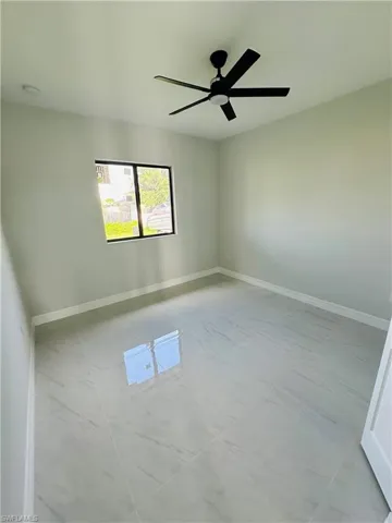 Tiled spare room with ceiling fan