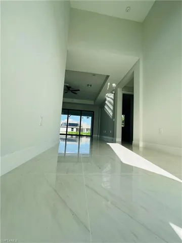 Tiled spare room featuring ceiling fan