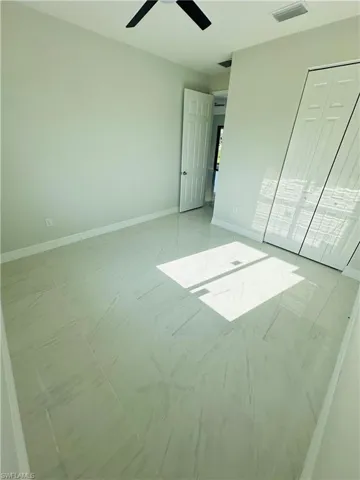 Unfurnished bedroom featuring ceiling fan, tile flooring, and a closet