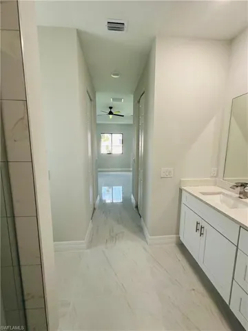 Bathroom featuring tile flooring, vanity, and ceiling fan