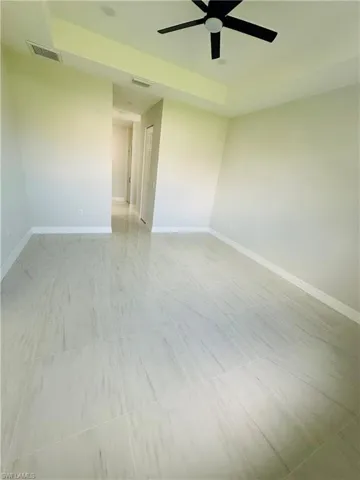 Empty room with tile flooring and ceiling fan