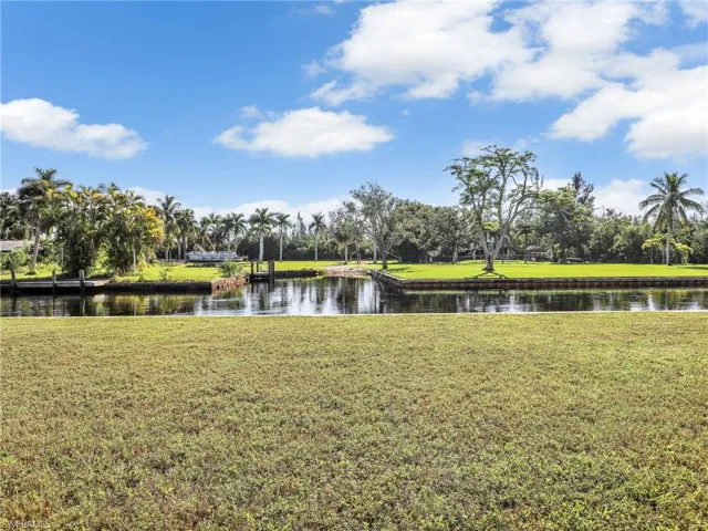 View of property's community featuring a lawn and a water view