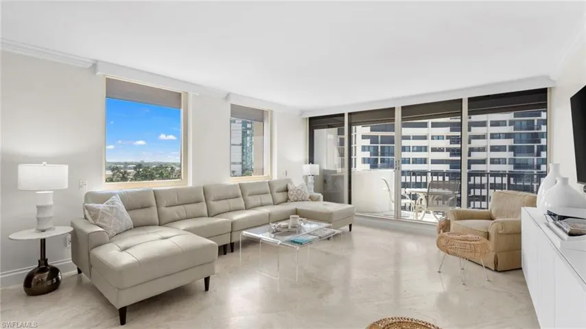 Living room featuring floor to ceiling windows and crown molding