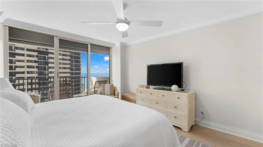 Bedroom featuring light wood-type flooring, ornamental molding, ceiling fan, and access to exterior