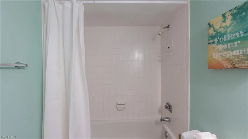 Bathroom with shower / bathtub combination with curtain
