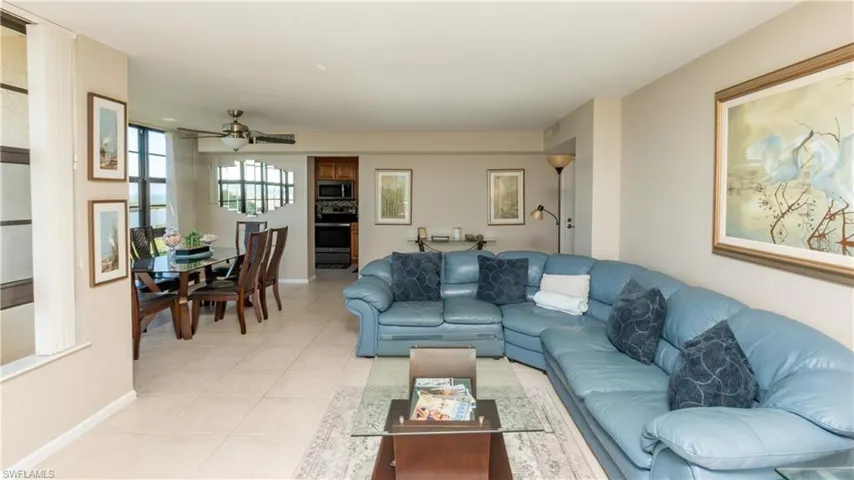 Living area with light tile patterned flooring and ceiling fan