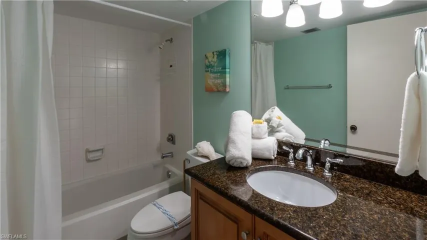 Bathroom featuring shower / bath combination with curtain and vanity
